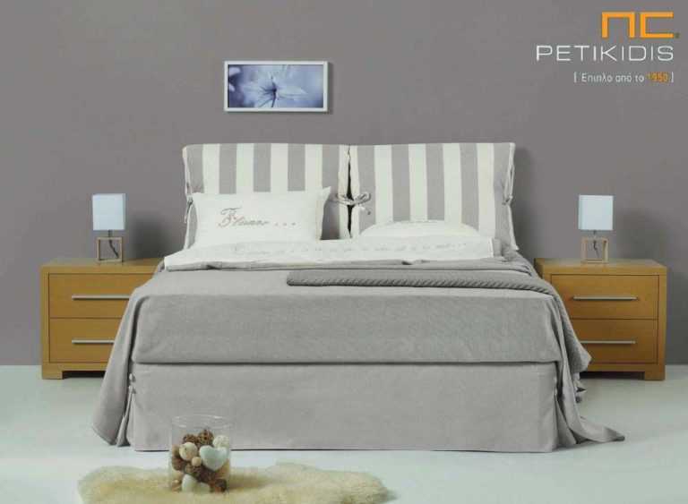 Υφασμάτινο κρεβάτι Lida της Linea Strom σε ύφασμα μπεζ μονόχρωμο αλέκιαστο και αδιάβροχο και ρίγες στις μαξιλάρες του κεφαλαριού. Το ύφασμα αφαιρείται από την βάση και το κεφαλάρι για εύκολο καθάρισμα.