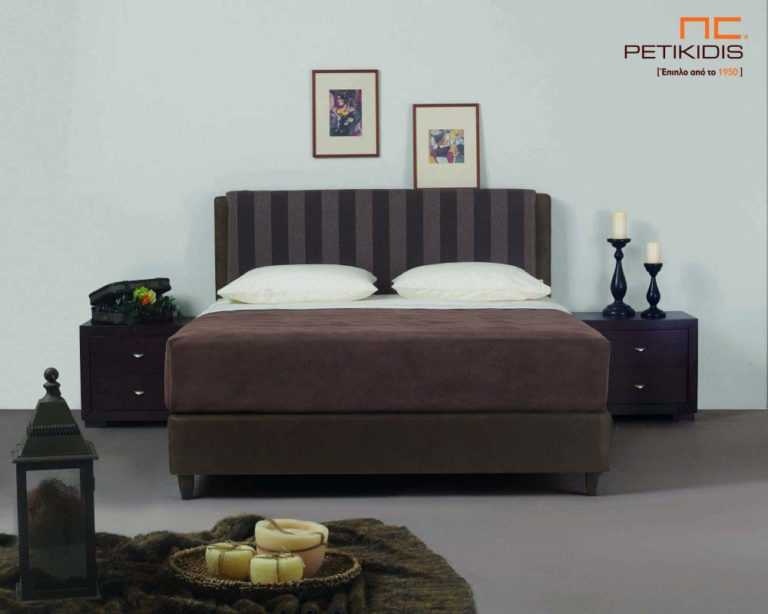 Υφασμάτινο κρεβάτι Mandi της Linea Strom σε καφέ ύφασμα μονόχρωμο αλέκιαστο και αδιάβροχο στη βάση και ρίγα στο κεφαλάρι. Το ύφασμα αφαιρείται από την βάση και το κεφαλάρι για εύκολο καθάρισμα.