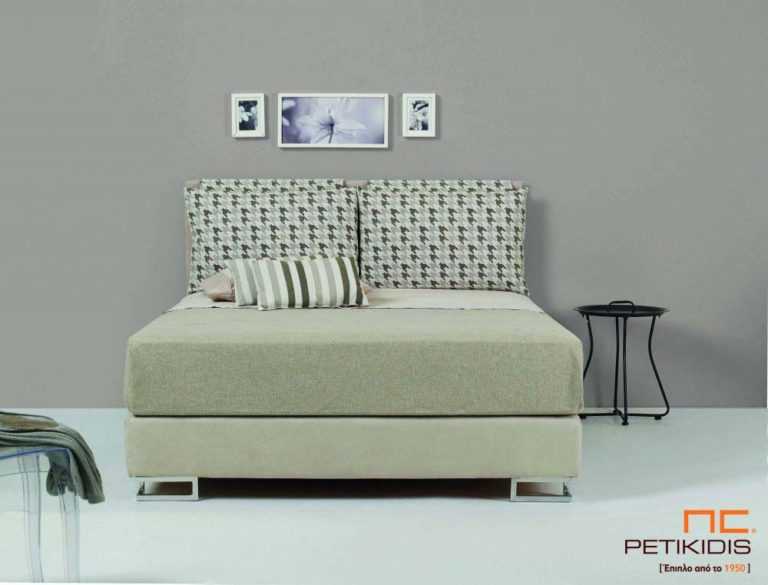 Υφασμάτινο κρεβάτι Milena της Linea Strom σε ύφασμα μπεζ μονόχρωμο αλέκιαστο και αδιάβροχο και σχέδια στις μαξιλάρες του κεφαλαριού. Το ύφασμα αφαιρείται από την βάση και το κεφαλάρι για εύκολο καθάρισμα .