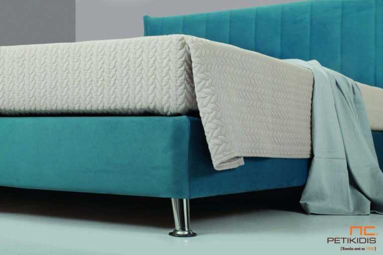 Υφασμάτινο κρεβάτι Tierra της Linea Strom σε ύφασμα μονόχρωμο αλέκιαστο και αδιάβροχο. Το κεφαλάρι έχει ελαφρύ καπιτονέ σχέδιοκαι το ύφασμα αφαιρείται από την βάση και το κεφαλάρι για εύκολο καθάρισμα . Λεπτομέρεια βάσης και ποδιού.