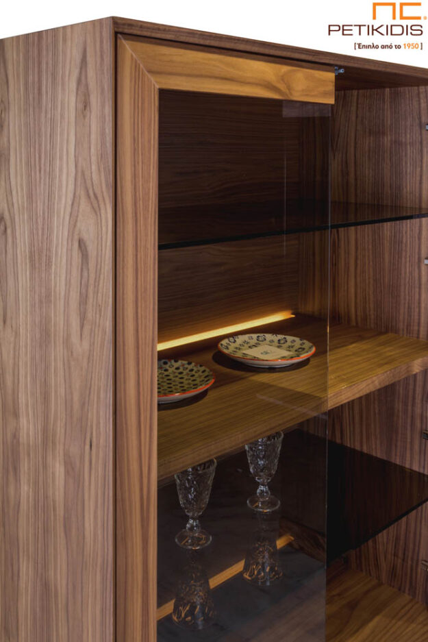 Βιτρίνα Vendome από ξύλο καρυδιάς και μεταλλικά πόδια. Ιδιαίτερο στοιχείο ο συνδυασμός του εσωτερικού φωτισμού με το φιμέ τζάμι στις πόρτες.