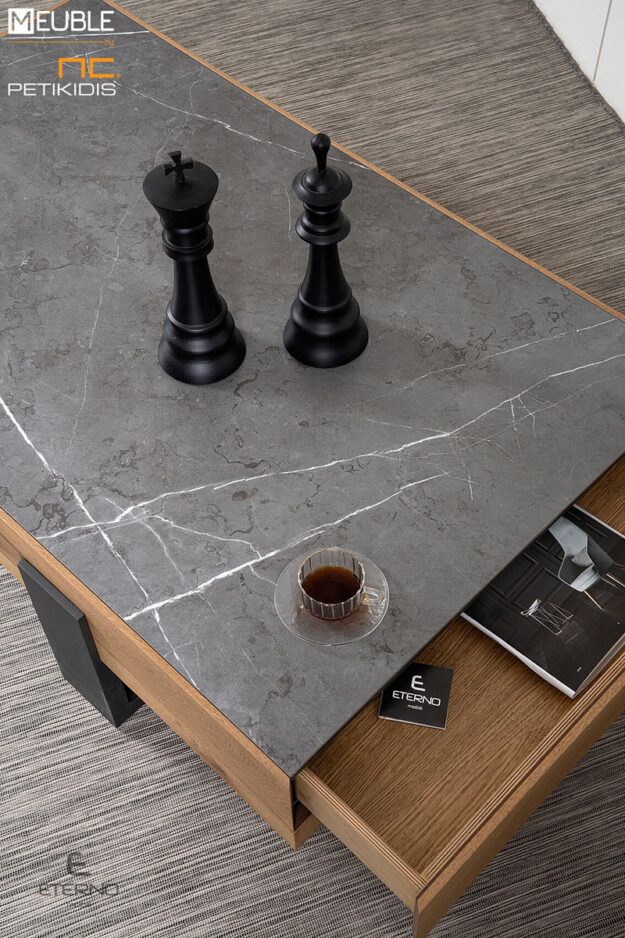 Ένα παραλληλόγραμμό μοντέρνο με αφαιρετικό ύψος είναι το τραπεζάκι Life. Διαθέτει συρτάρι που εξυπηρετεί τις ανάγκες αποθήκευσης. Τα υλικά κατασκευής του είναι το ξύλο δρυς ρουστίκ σε συνδυασμό με λάκα γκοφρέ και κεραμική επιφάνεια. Λεπτομέρεια.