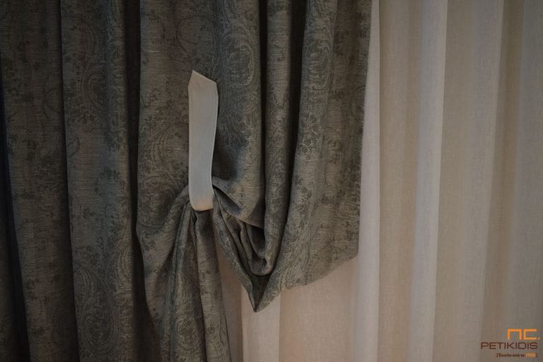Κουρτίνα πλαϊνή ΝοC22/02 από ύφασμα σε σχέδιο με λαχούρι σε γκρι χρώμα. Το φάρδος του είναι 3,20μ και η σύνθεσή του είναι 55% λινό και 45% polyester.Το πιάσιμό της είναι από πιάστρα με μαγνήτες και δεν χρειάζεται να γίνει τρύπα στον τοίχο. Η λεπτή κουρτίνα είναι λευκή μονόχρωμη NoC20/01. Το φάρδος της είναι 3,30μ και η σύνθεσή της είναι 100% λινό. λεπτομέρεια δεσίματος.