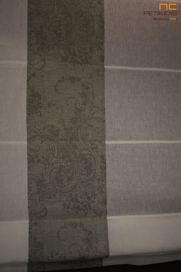 Κουρτίνες Κουρτίνα σε μορφή ρόμαν με μηχανισμό και συνδυασμό από ΝοC22/02 από ύφασμα σε σχέδιο με λαχούρι σε γκρι χρώμα. Το φάρδος του είναι 3,20μ και η σύνθεσή του είναι 55% λινό και 45% polyester. Η λευκή κουρτίνα είναι η ΝοC20/01.Το φάρδος της είναι 3,30μ και η σύνθεσή της είναι 100% λινό. Λεπτομέρεια συνδυασμού και ραφής.