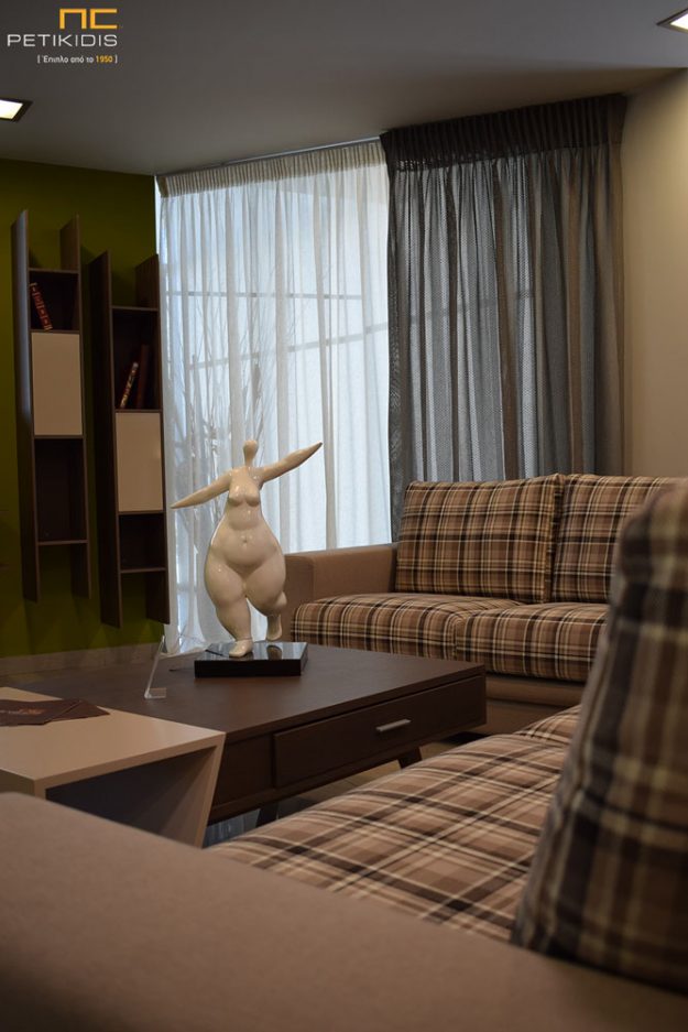 Κουρτίνες Κουρτίνα από λινό ύφασμα σε μπεζ απόχρωση και καφέ δίχτυ συνδυασμένο με ύφασμα επιπλώσεων σε καρό.