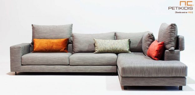 Μοντέρνο Σαλόνι Σαλόνι γωνία Nouovo με δυνατότητα να τοποθετηθεί το μαξιλάρι της πλάτης για μεγαλύτερη ανάπαυση. Το ύφασμα είναι σε γκρι αποχρώσεις και διαθέτει χρωματιστά διακοσμητικά μαξιλάρια.